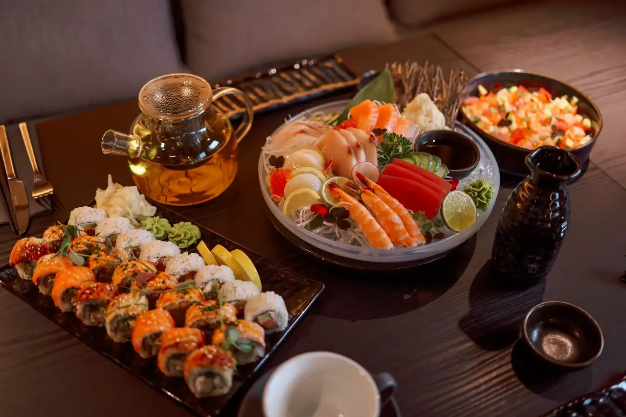 Table arrangement featuring sushi, ceramic teapot and minimalist side dishes