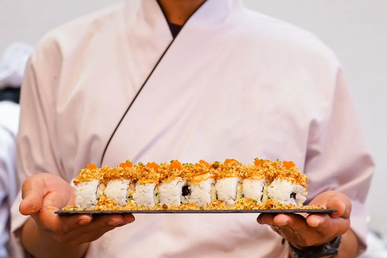 Plated sushi roll with delicate garnishes on a stone plate