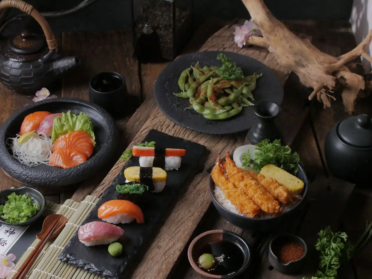 Assortment of fresh nigiri and steamed edamame on warm timber table