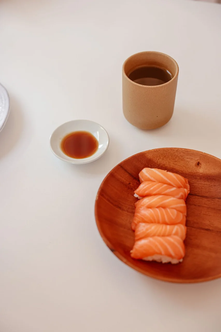 Aesthetic still life of sushi, brewed sencha green tea and artisanal soy dish