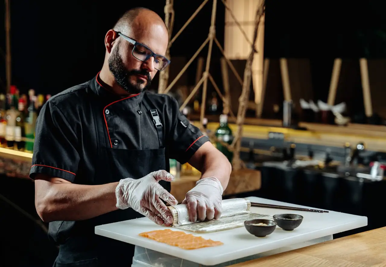 Sushi culinary lead in uniform assembling nigiri